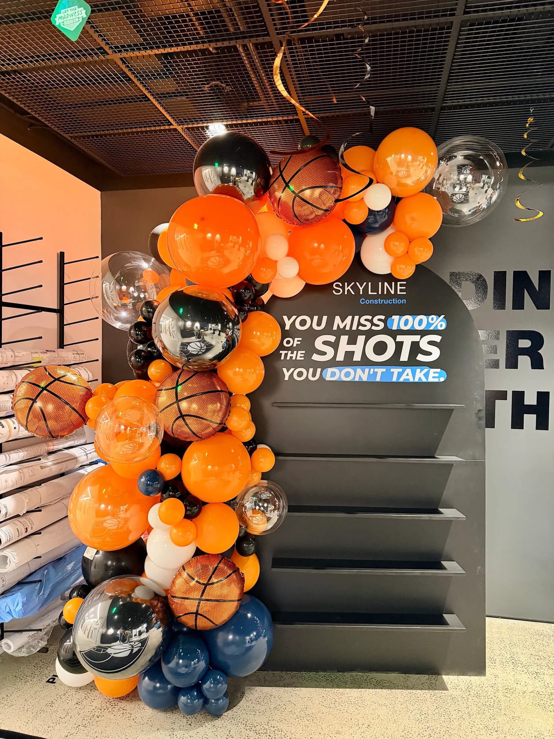 Basketball-themed garland and branded columns for Skyline Construction at the March Madness Office Event in San Francisco Bay Area.